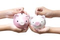 Two kids holding and putting coins into piggy banks Royalty Free Stock Photo