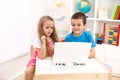 Two kids looking at laptop computer