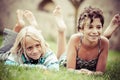 Two kids lying on top of grass