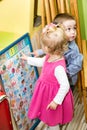 Two kids in Montessori preschool Class. Little girl and boy playing