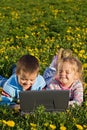 Two kids outdoors having fun with a laptop Royalty Free Stock Photo