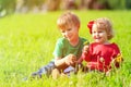 Two kids playing with dandelions on green grass Royalty Free Stock Photo