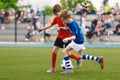 Two Kids Playing Football Ball on Grass Field. Happy School Boys Kicking Ball During Tournament Game