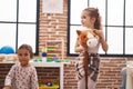 Two kids playing with horse toy at kindergarten Royalty Free Stock Photo