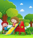 Two kids playing slide in park Royalty Free Stock Photo