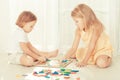 Two kids playing with wooden mosaic in their room Royalty Free Stock Photo