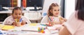 Two kids preschool students having lesson with teacher at classroom