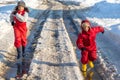 Two kids in rainboots running on the ice puddle Royalty Free Stock Photo