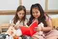 Two kids reading story book sitting on bed at bedroom Royalty Free Stock Photo