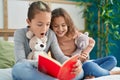 Two kids reading story book sitting on bed at bedroom Royalty Free Stock Photo