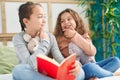 Two kids reading story book sitting on bed at bedroom Royalty Free Stock Photo