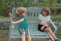 Two kids relaxing outdoors at summer park. Brother and sister happy walking in nature. Siblings boy and girl playing in