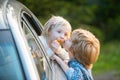 Two kids saying goodbye before car travel. Bye bye.