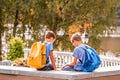 Two boys after school, sitting on bench and talking Royalty Free Stock Photo
