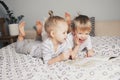Two kids sitting on bed and reading a book Royalty Free Stock Photo