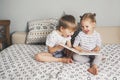 Two kids sitting on bed and reading a book Royalty Free Stock Photo