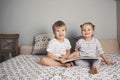 Two kids sitting on bed and reading a book Royalty Free Stock Photo