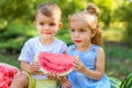 Two kids sitting between watermelons in the garden. Kids eat fruit outdoors. Healthy snack for children. 2 years old Royalty Free Stock Photo