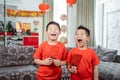 Two kids smile in red shirts with angpau Royalty Free Stock Photo