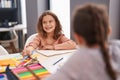 Two kids students sitting on table drawing on notebook paper at classroom Royalty Free Stock Photo