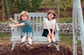 Two kids swinging and relaxing outdoors at summer park. Brother and sister happy walking in nature. Siblings boy and Royalty Free Stock Photo