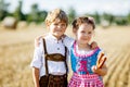 Two kids, boy and girl in traditional Bavarian costumes in wheat field Royalty Free Stock Photo