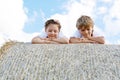 Two kids, boy and girl in traditional Bavarian costumes in wheat field with hay bales Royalty Free Stock Photo