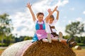 Two kids, boy and girl in traditional Bavarian costumes in wheat field with hay bales Royalty Free Stock Photo