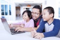 Two kids using laptop with dad at home Royalty Free Stock Photo