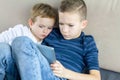 Two kids using tablet pc at home, modern education technology. Brothers with tablet computer in light room. Royalty Free Stock Photo