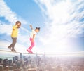 Two kids walking over the rope in modern city