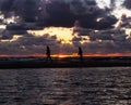Two kids on a sandbar during sunset