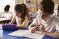 Two kids working at their desks in primary school, close up Royalty Free Stock Photo