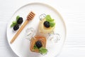 Two kinds of honey in glass jars and on a white plate. Blackberries and mint with honey. The view from the top. Natural product