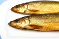 Two kippers, smoked herring on white plate Royalty Free Stock Photo