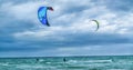 Two kite surfers, rough sea and stormy sky