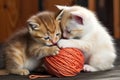 two kittens wrestling for control of a ball of yarn