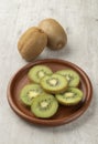 Two kiwis with slices on a wooden board Royalty Free Stock Photo