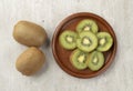 Two kiwis with slices on a wooden board Royalty Free Stock Photo