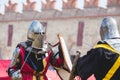 Two knights during a duel on the background of the wall of the ancient castle_ Royalty Free Stock Photo