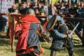 Two knights fight in the arena in front of the audience. Royalty Free Stock Photo