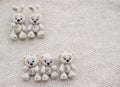 Two knitted white bunnies and three bears