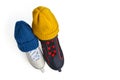 Two knitted winter hats of blue and yellow colors are put on men's and women's ice skates isolated on a white Royalty Free Stock Photo