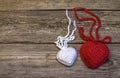 Two knitting hearts on old wooden panel