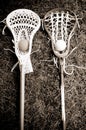 Two lacrosse heads and sticks with ball on grass