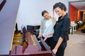 Two ladies looking at piano