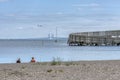 Two ladies sitting on the beach in front of the Kastrup Sea Baths