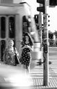 Two ladies waiting on the traffic light, waiting for the green sign to cross the street