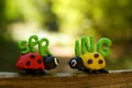Two ladybugs made of plasticine on a colored background. Next to it is the inscription spring Royalty Free Stock Photo