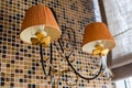 Two-lamp sconce with two fabric orange lampshades. Classic wall lamp in restaurant or hotel Royalty Free Stock Photo